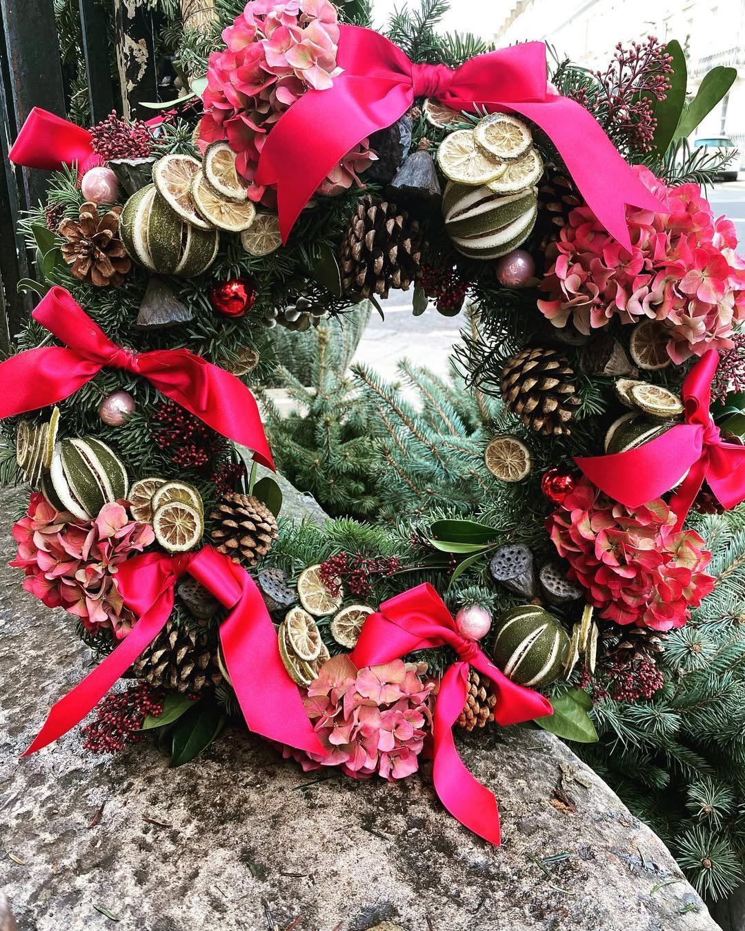 Christmas wreath with pine cones and red ribbon from our Gurnee Flower Shop.