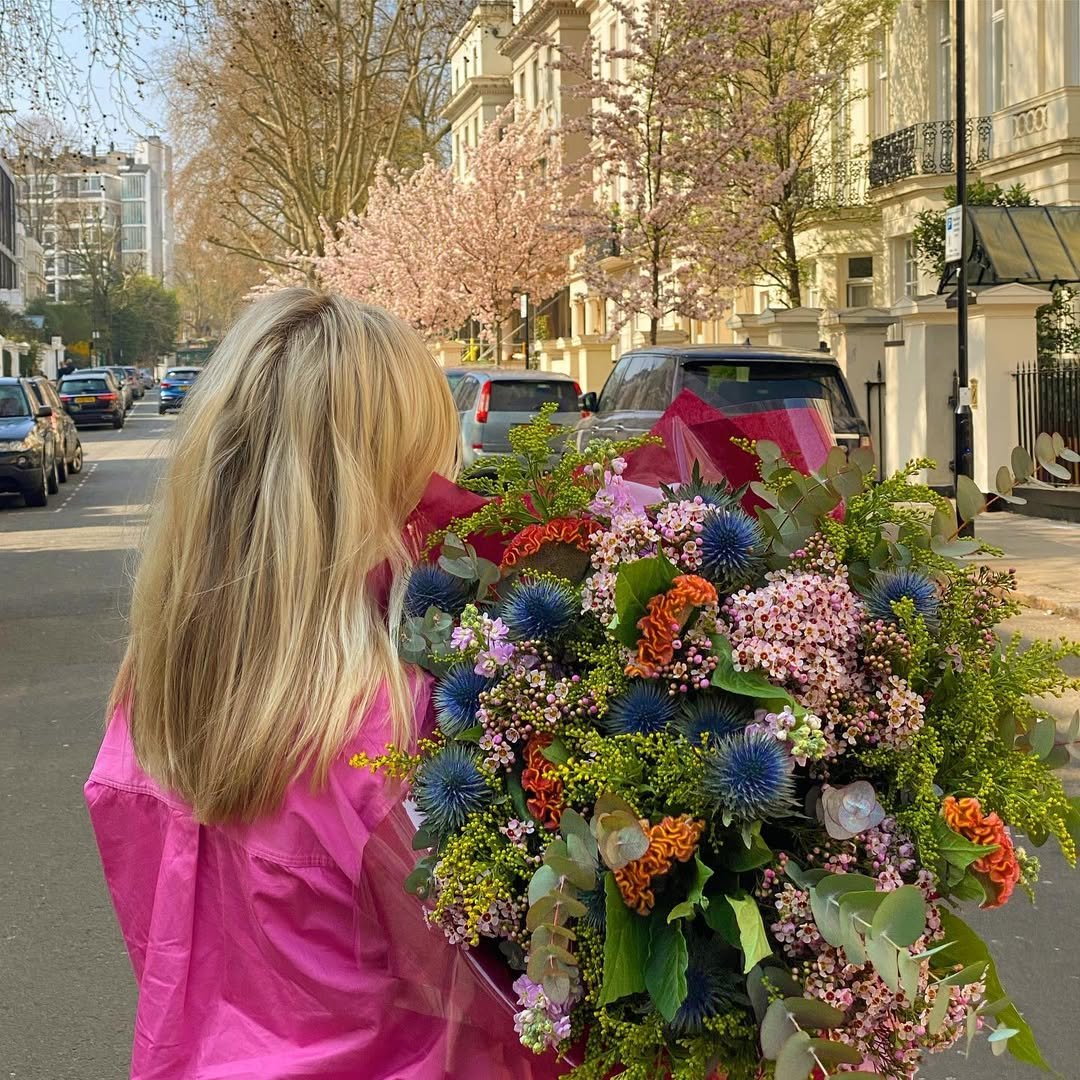 Woman carrying a colorful spring bouquet from our Gurnee Flower Shop.