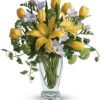 Yellow lily and white rose bouquet in clear glass vase