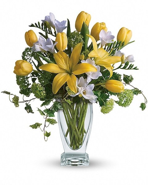 Yellow lily and white rose bouquet in clear glass vase