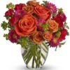 Orange rose and red mixed flower bouquet in glass vase