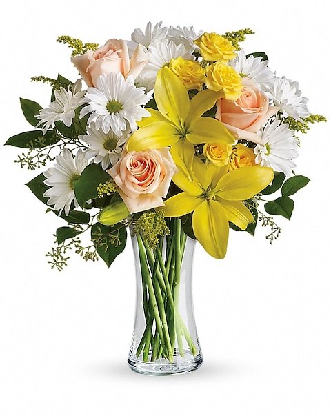 Yellow lily and pastel rose bouquet in clear glass vase