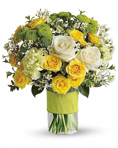 White lily and pastel rose bouquet in purple glass vase