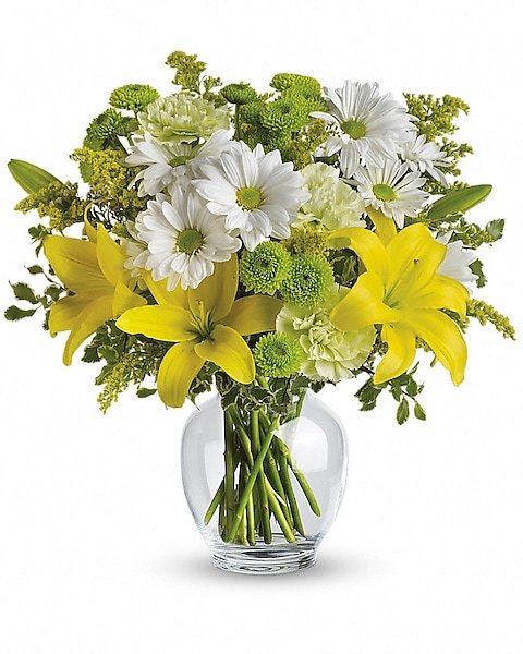 Yellow lily and white daisy bouquet in clear vase