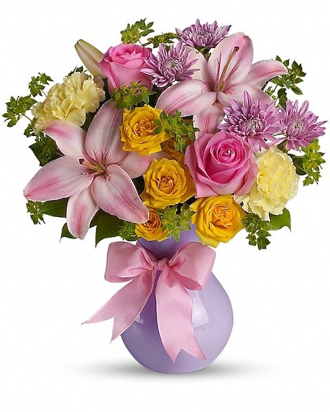 White lily and pastel rose bouquet in clear glass vase