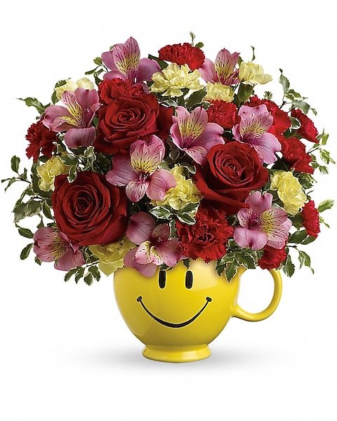 Red and pink rose floral arrangement in smiley mug from Gurnee florist