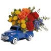 Mixed rose and yellow flower arrangement in blue truck planter