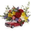 Mixed flower arrangement in red pickup truck planter