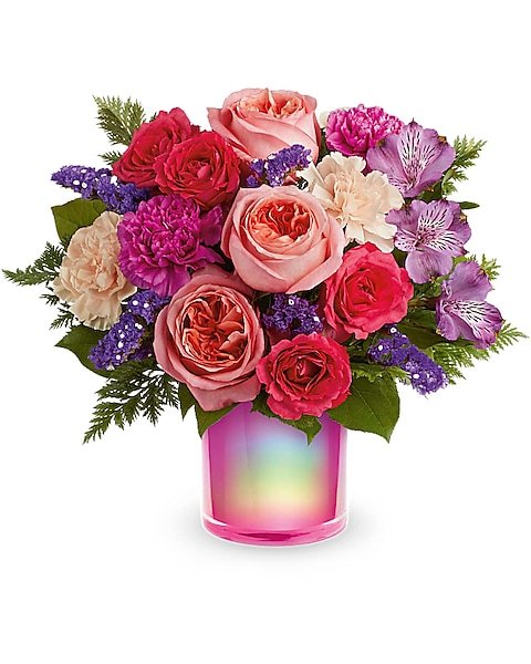 Yellow and pink rose bouquet tied with ribbon in glass vase