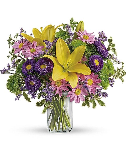 White lily and purple accent flower bouquet in glass vase