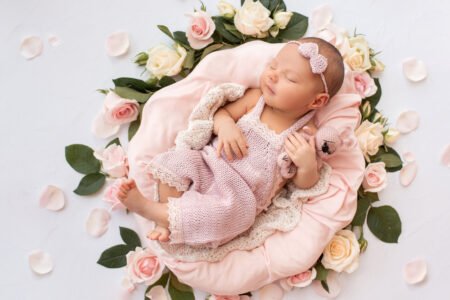 Newborn baby surrounded by soft floral arrangements from our Gurnee Flower Shop.