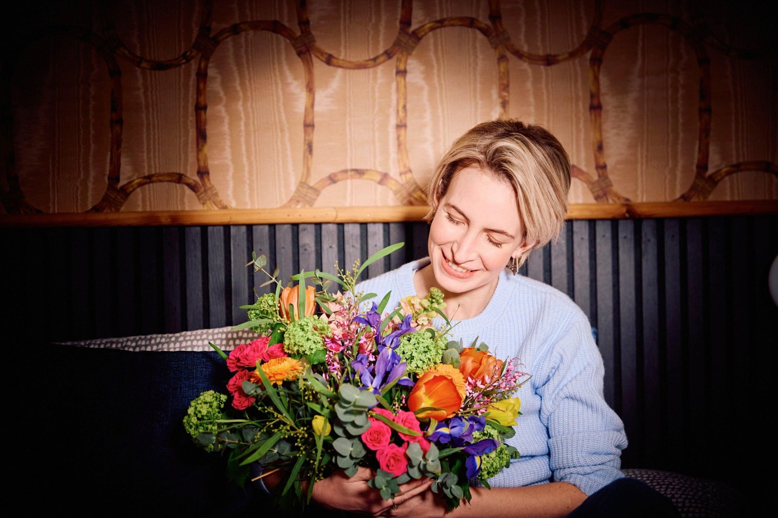 Woman holding a vibrant bouquet at our Gurnee Flower Shop, featuring fresh colorful flowers.